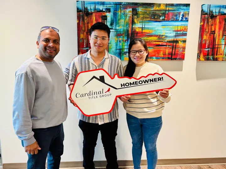 Clients holding a Homeowner key sign with their agent after closing