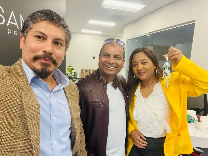 Buyers holding up their new house keys with their agent