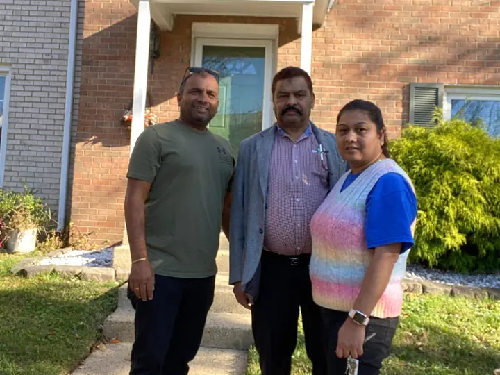 Agent with clients outside their new brick townhome