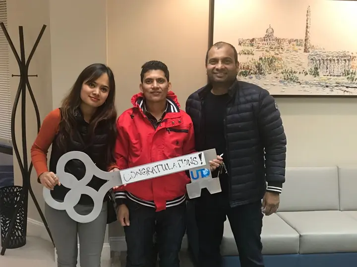 Three people with the congratulations key after closing