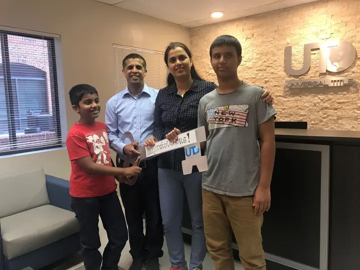 Family of four with the congratulations key at closing