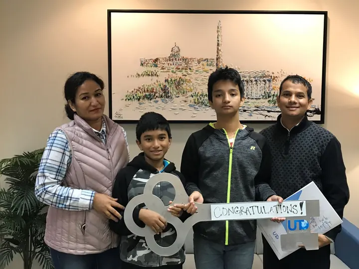 Family of four with the congratulations key