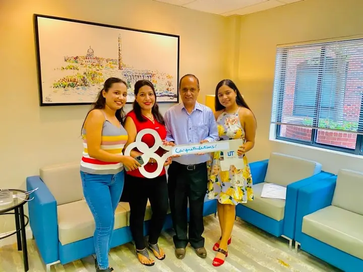 Four people smiling with the congratulations key