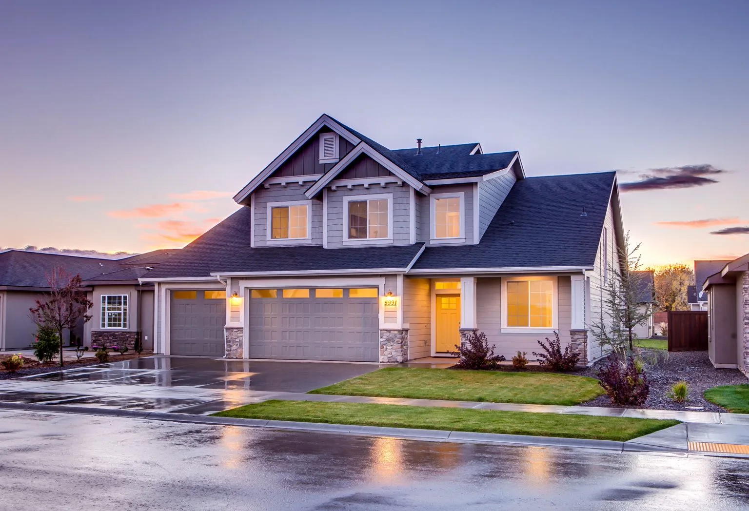 Illustrative detached home with a garage at dusk